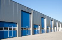 Commercial Mortgages - large metal property with row of blue garage doors